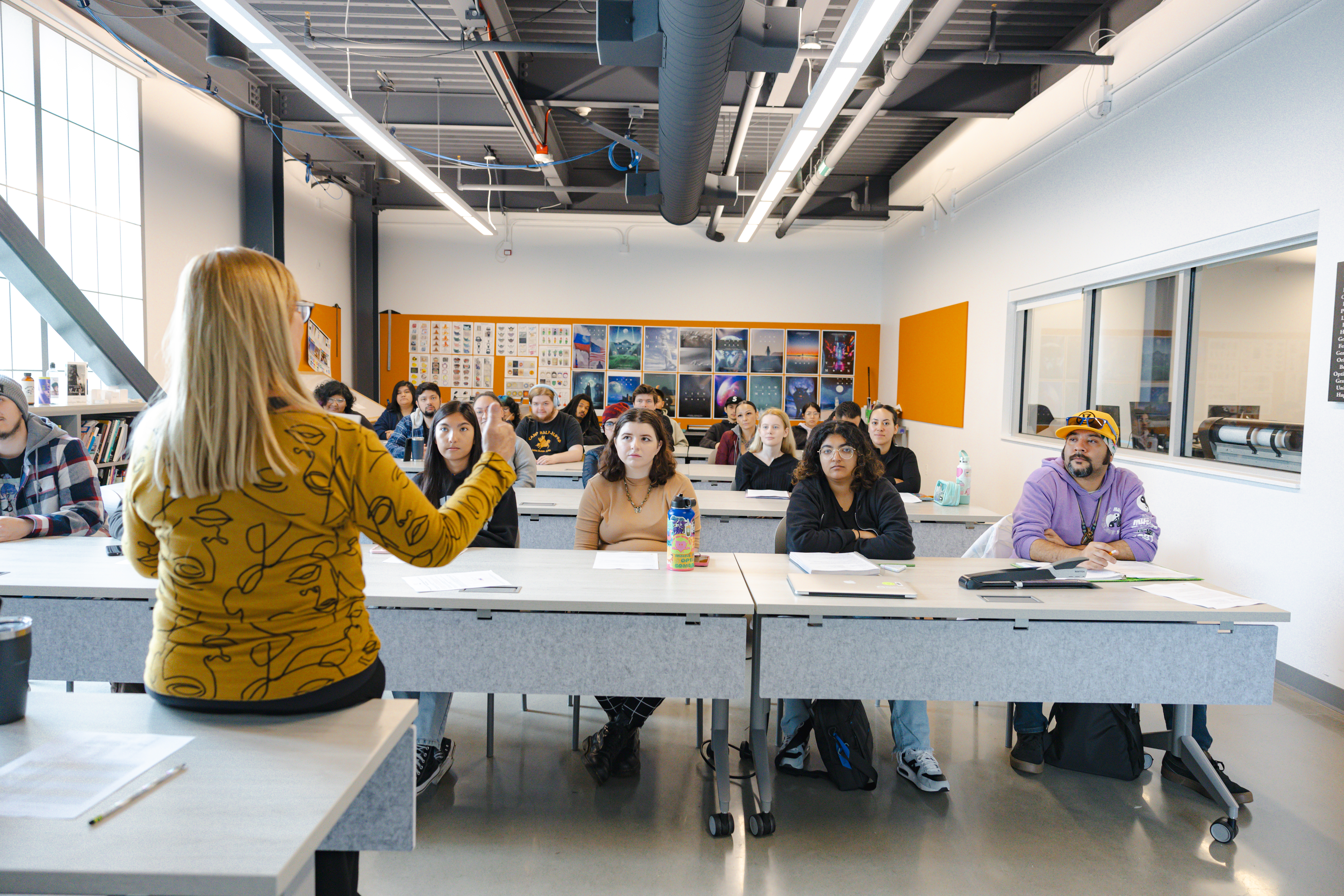 Hancock students sit at their desks and listen intently as their professor talks. 